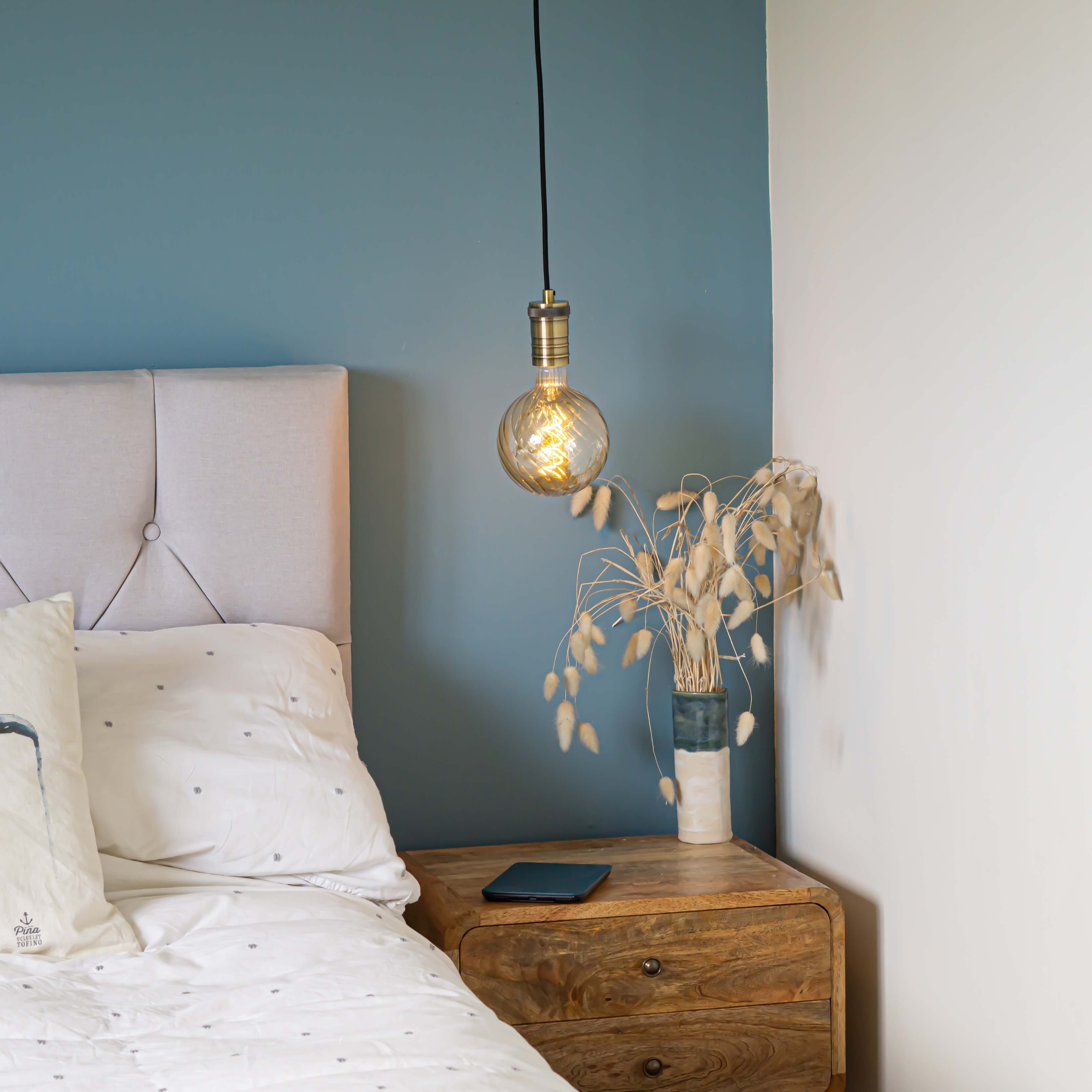 antique bronze pendant light and straight cable with felicity bulb hanging above the bedside table