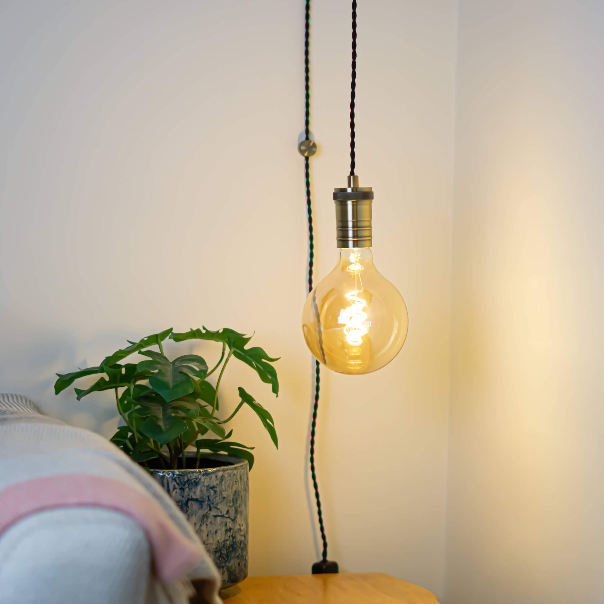 antique bronze plug in pendant light and twisted cable sophia bulb in living room on