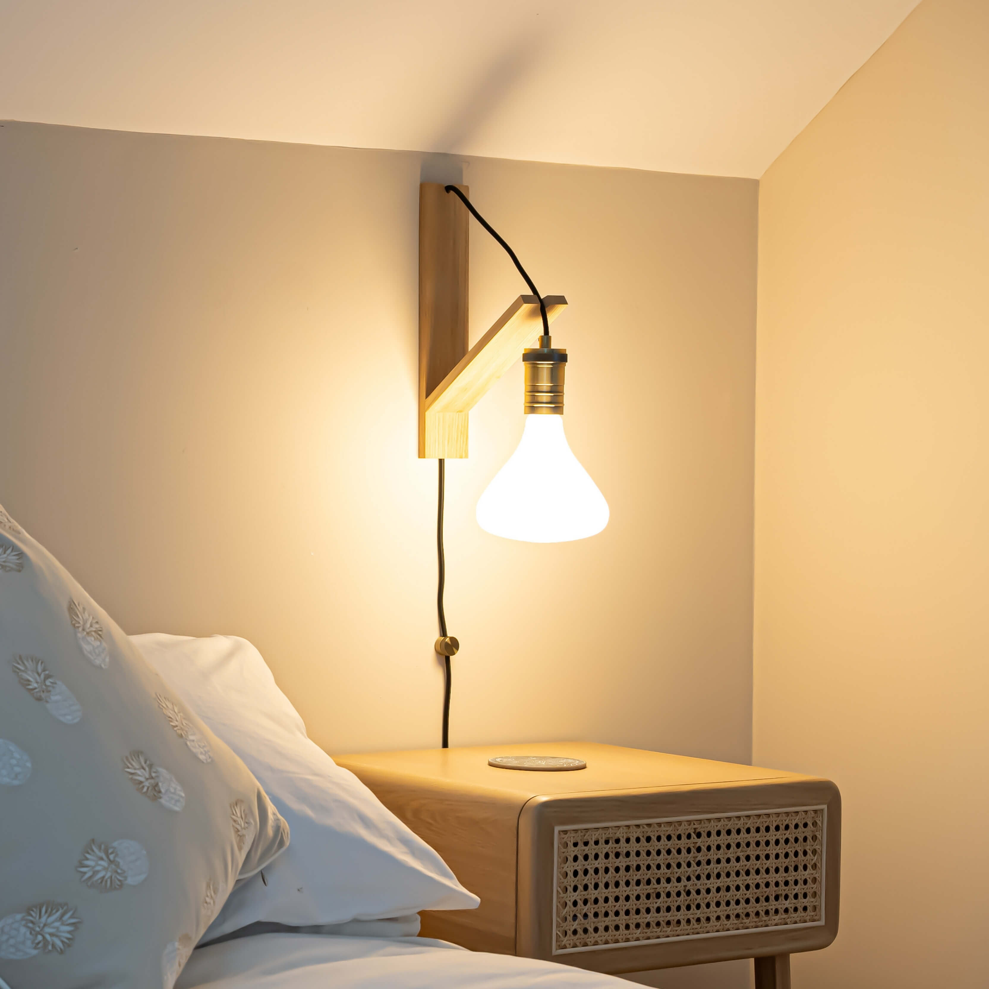 astrid plug in antique brass wall light with straight cable mounted by a bed