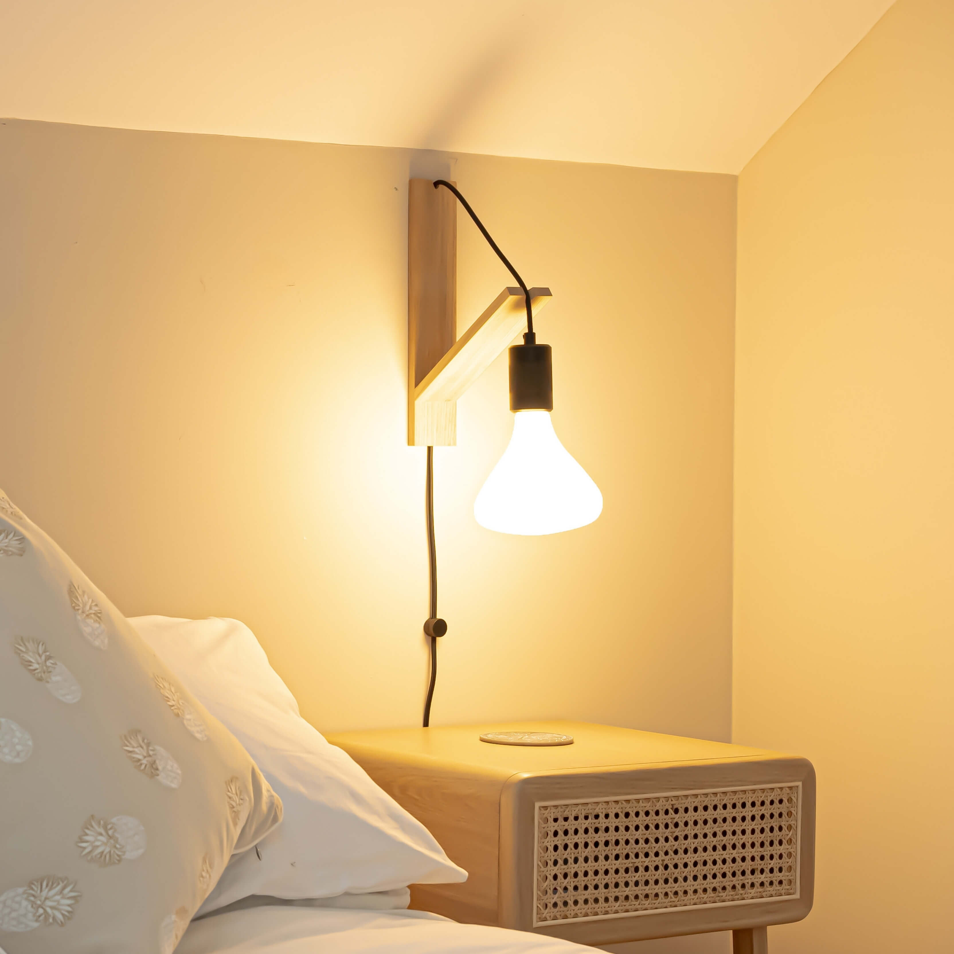 astrid plug in antique brass wall light with straight cable mounted by a bed