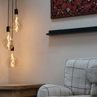 Black cluster pendant with Celeste bulbs to the side of the sofa