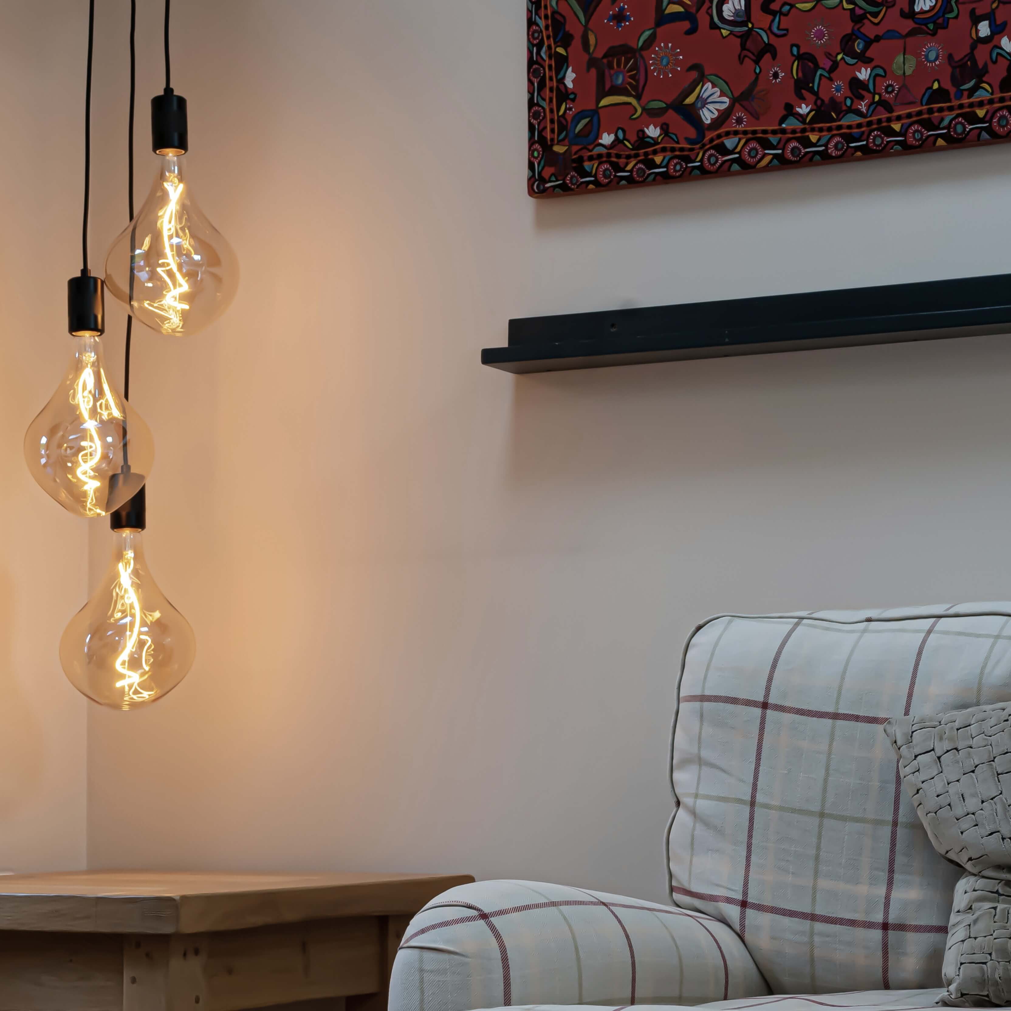 Black cluster pendant with Celeste bulbs to the side of the sofa