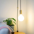 brass plug in pendant light and straight cable luna bulb in living room on