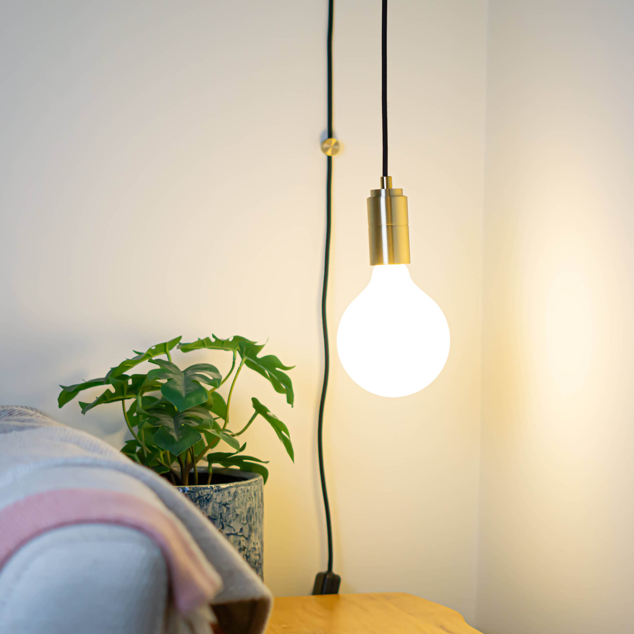 brass plug in pendant light and straight cable luna bulb in living room on