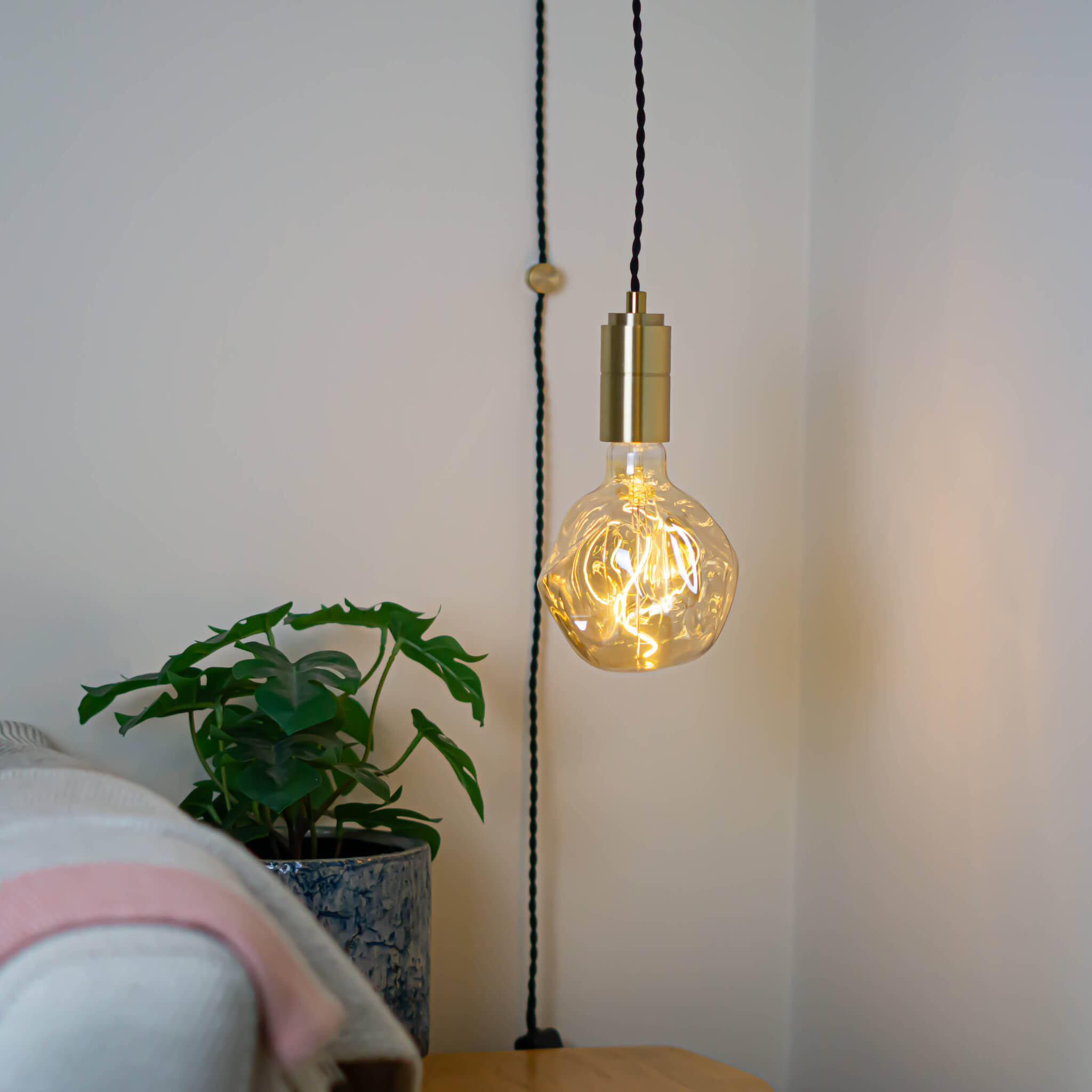brass plug in pendant light and twisted cable isabella bulb in living room on