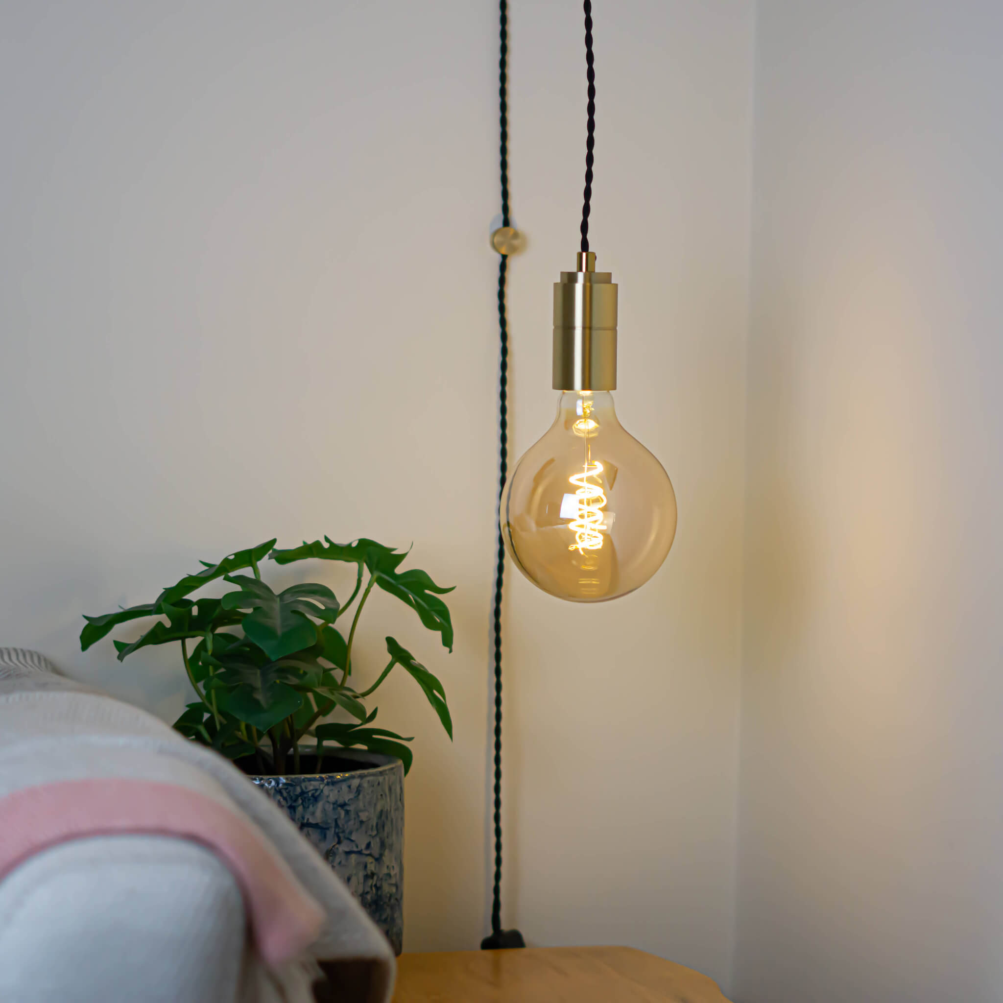 brass plug in pendant light and twisted cable sophia bulb in living room on