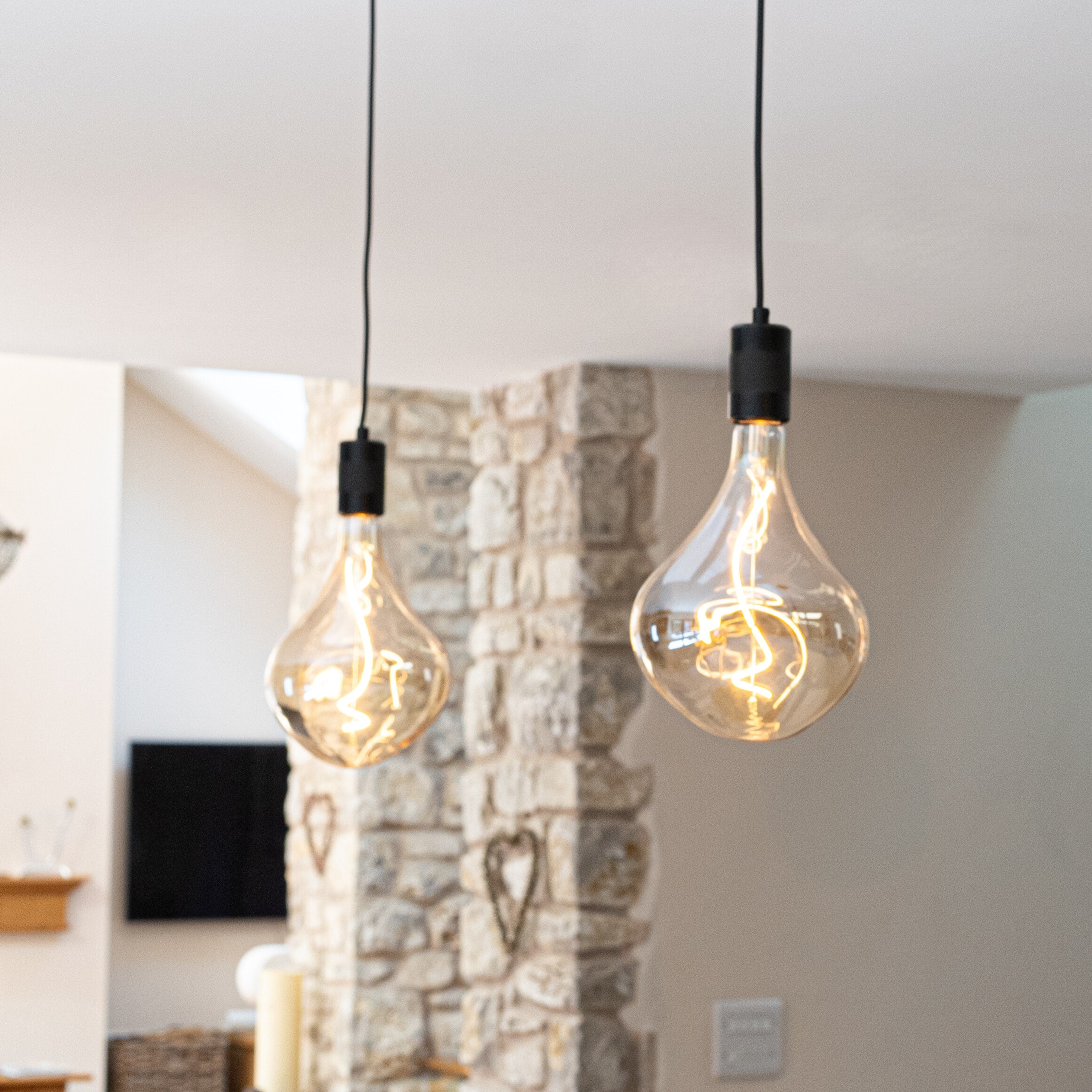 celeste matte black pendant light filaments showing suspended over a kitchen island AM3308-CEL-BLA-ST