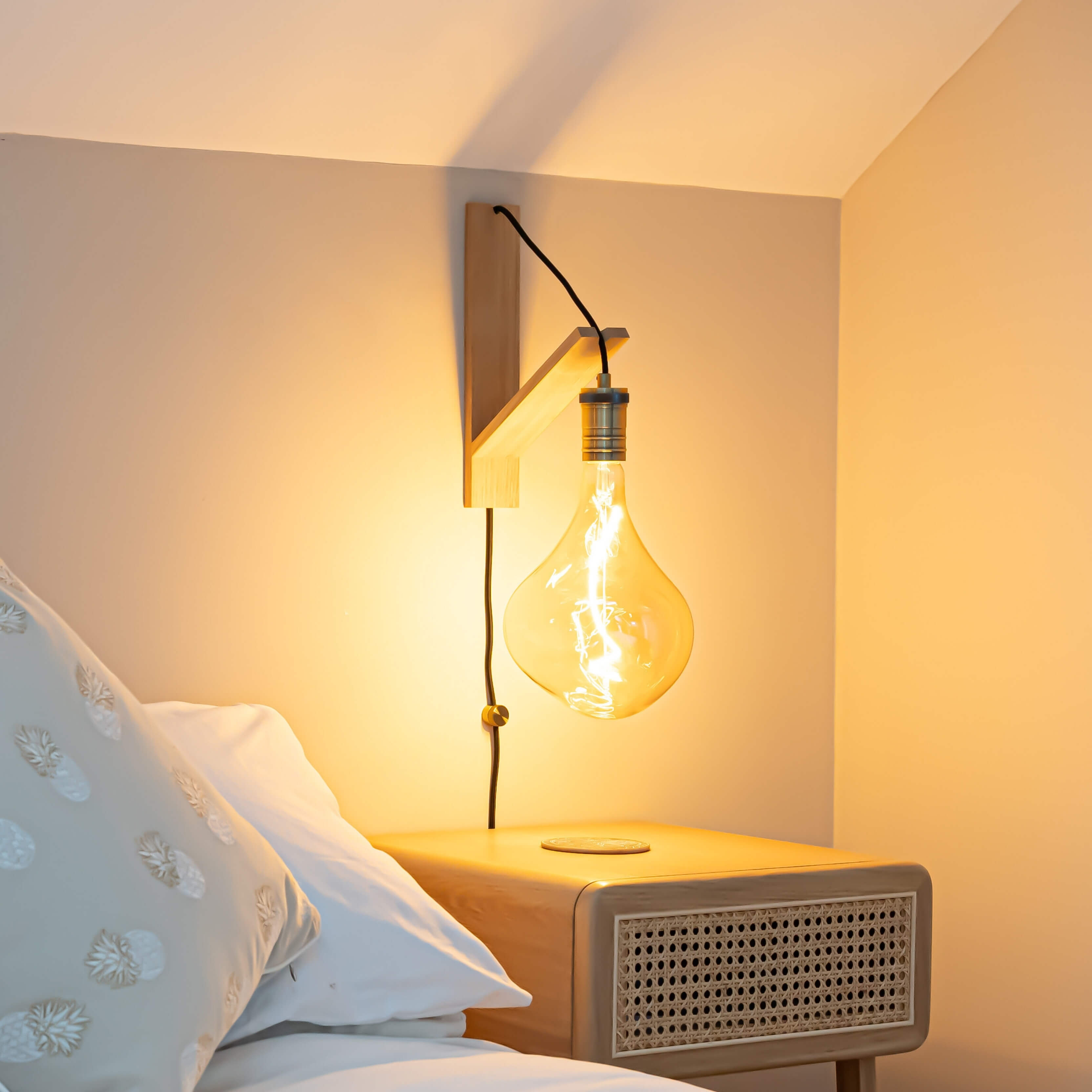 celeste plug in antique brass wall light with straight cable mounted by a bed