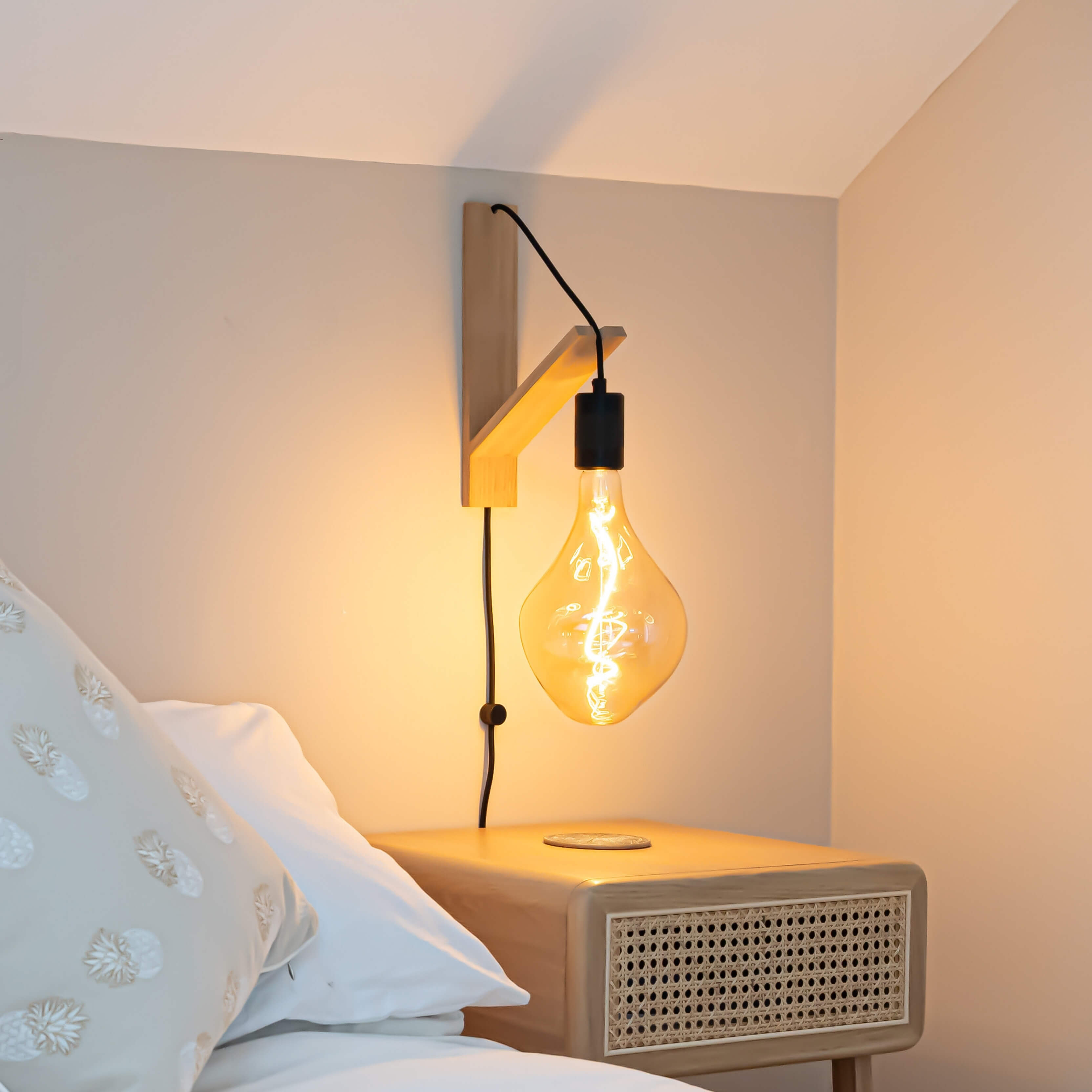 celeste plug in antique brass wall light with twisted cable mounted by a bed