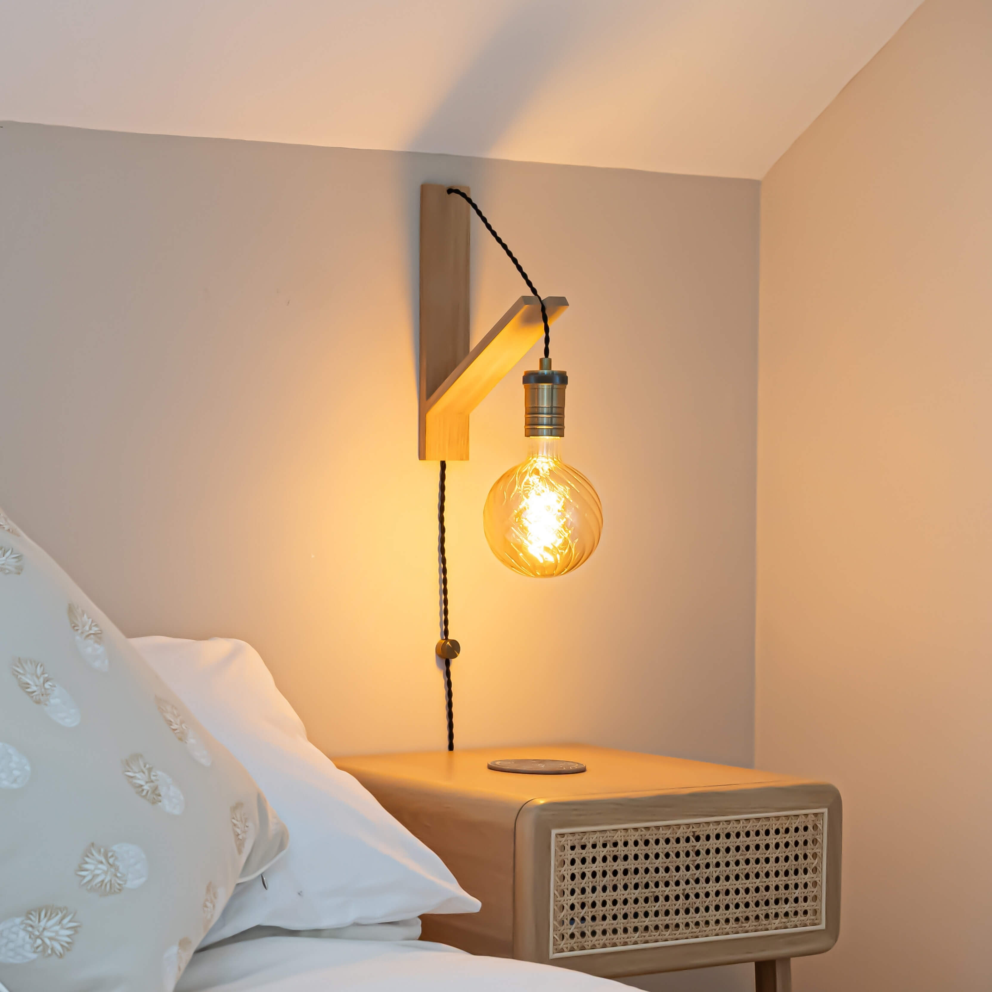 felicity plug in antique brass wall light with twisted cable mounted by a bed