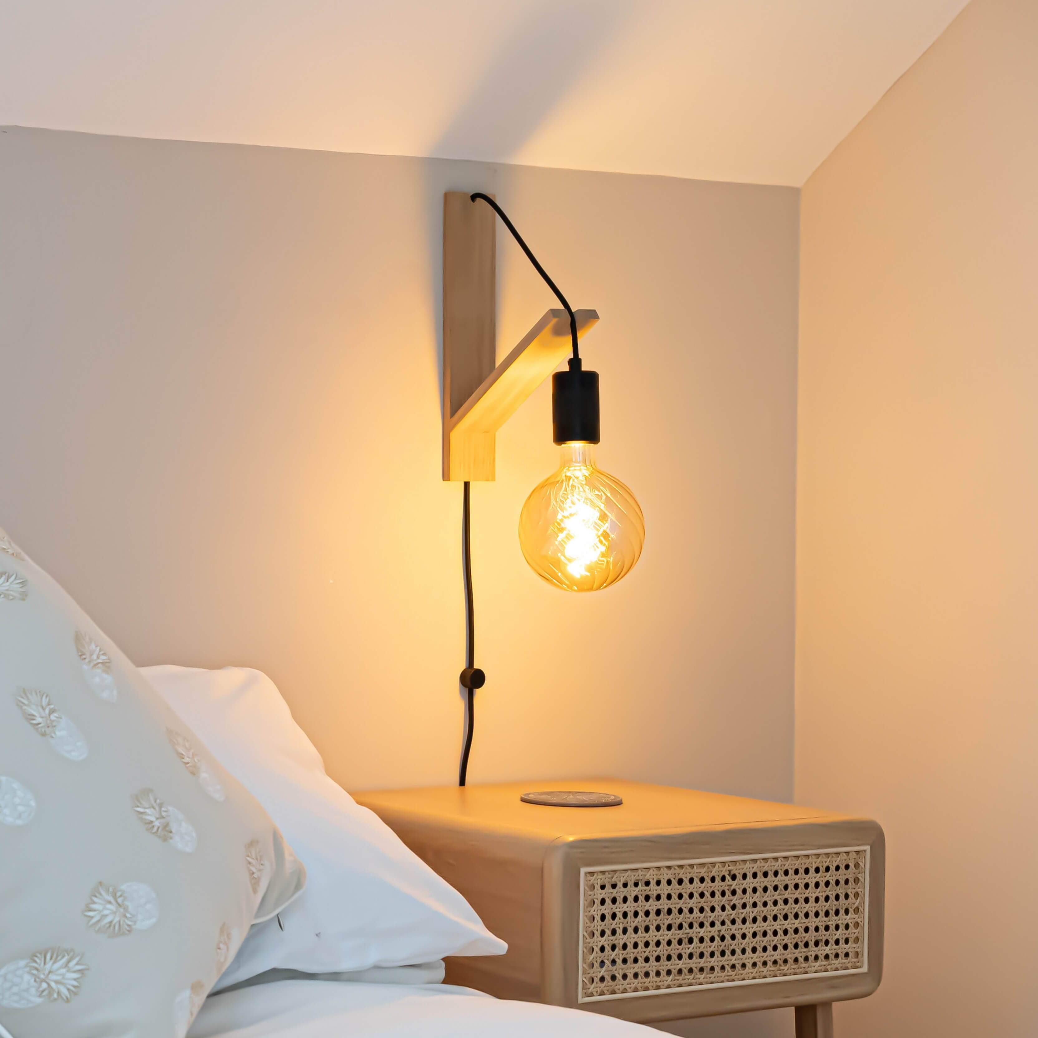 felicity plug in matte black wall light mounted by a bed