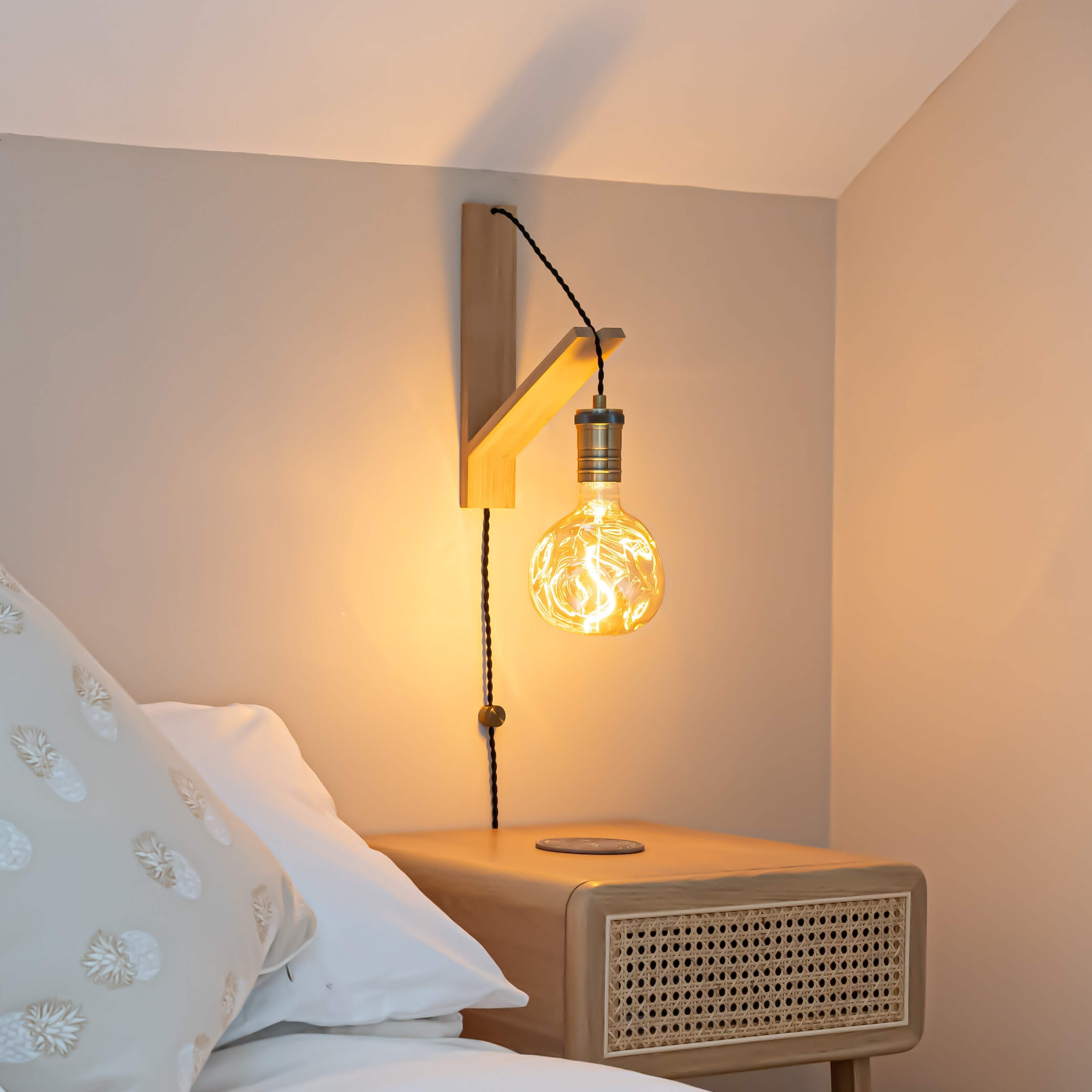 isabella plug in antique brass wall light with twisted cable mounted by a bed