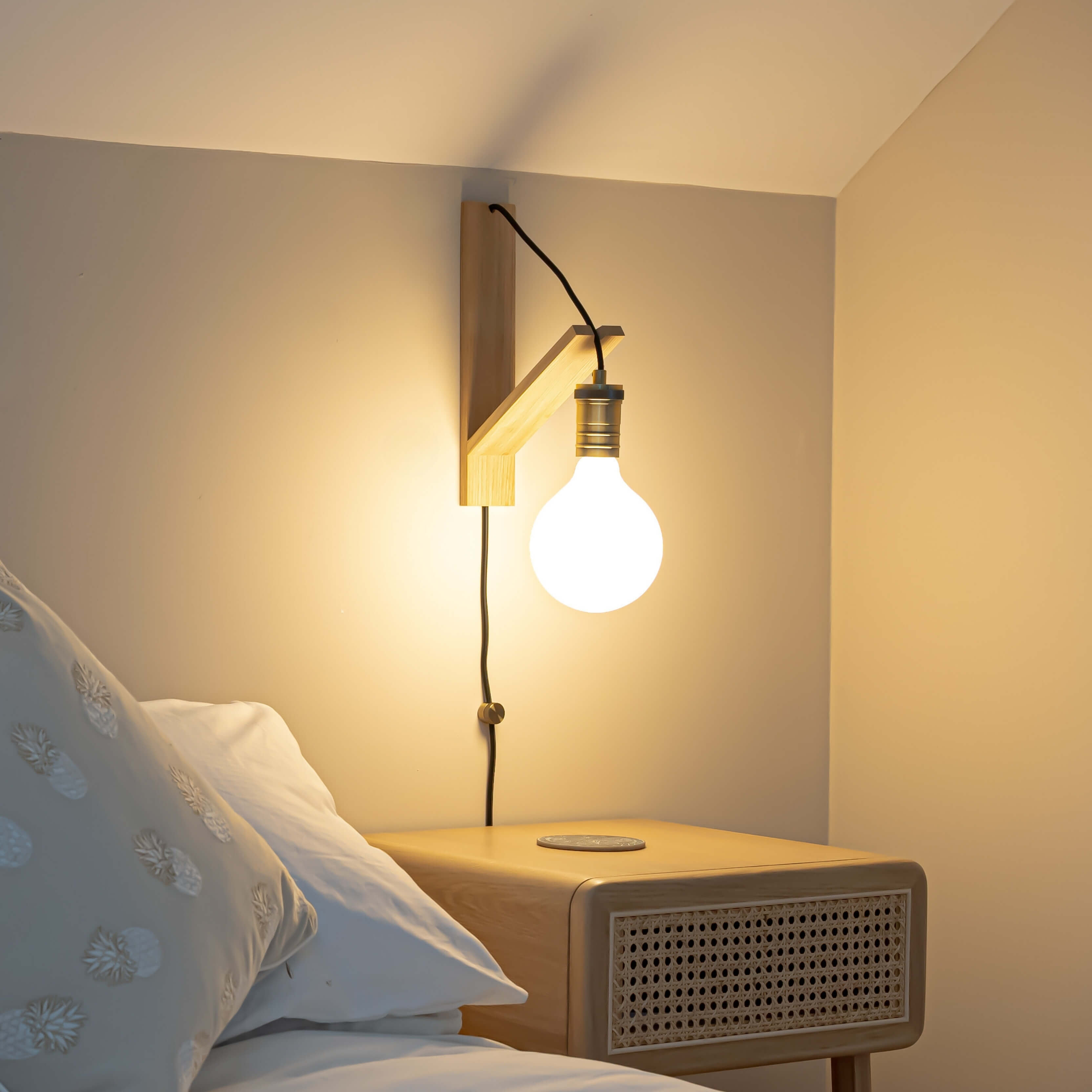 luna plug in antique brass wall light with straight cable mounted by a bed