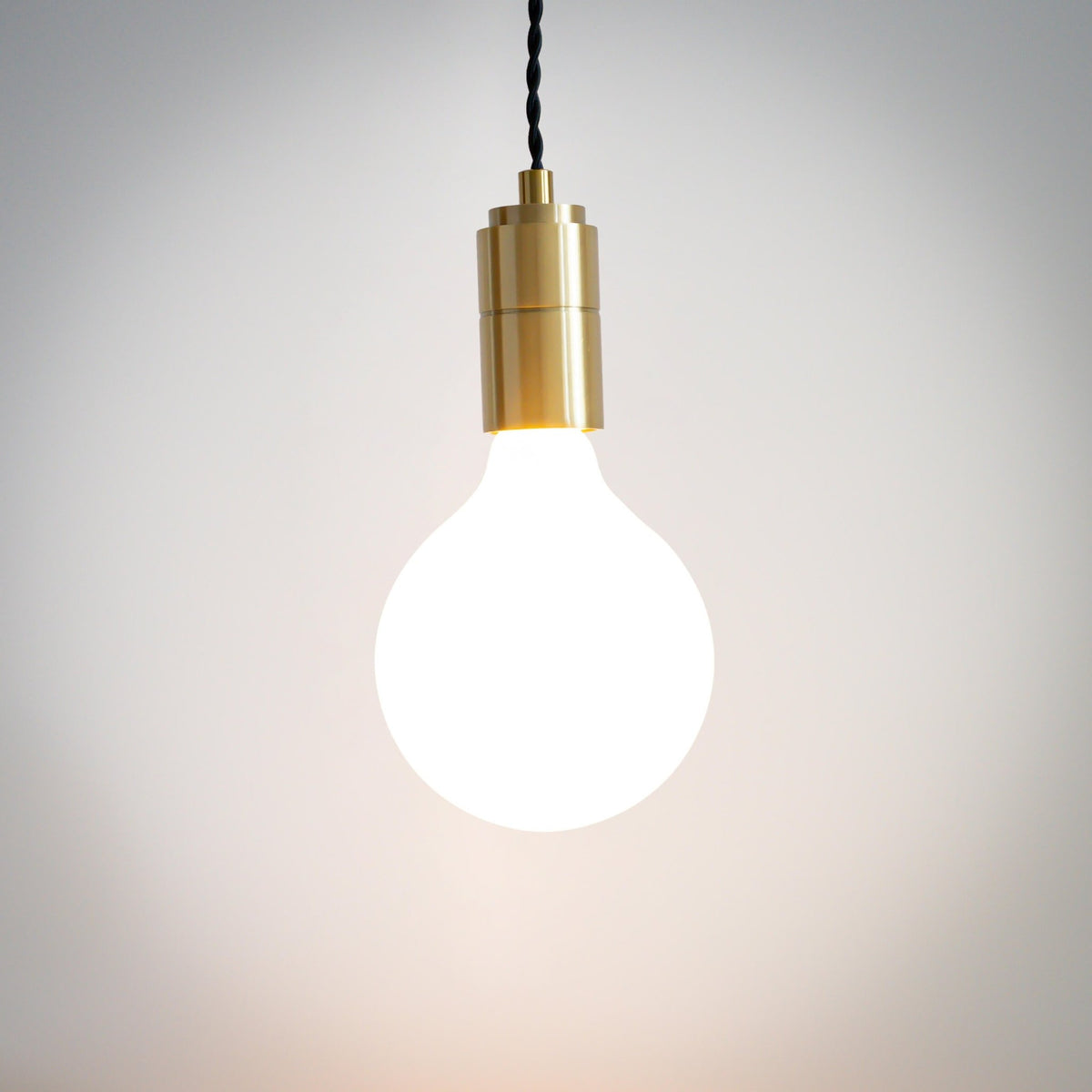 brass pendant light with twisted cable and luna bulb on