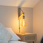 olivia plug in antique brass wall light with twisted cable mounted by a bed