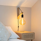 olivia plug in matte black wall light mounted by a bed