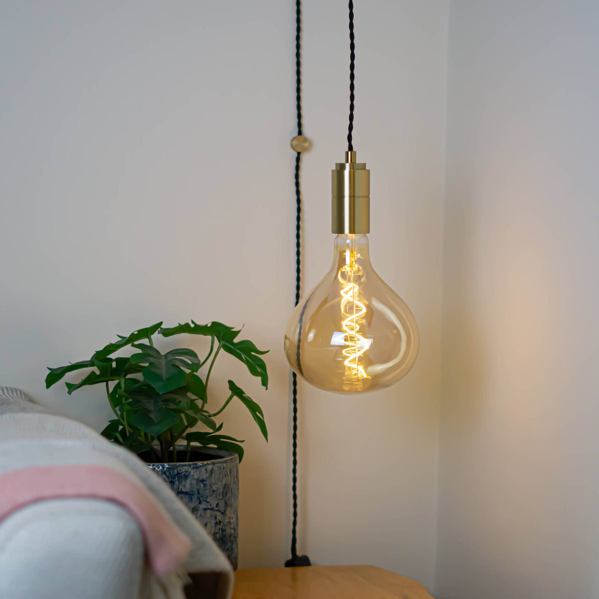 brass plug in pendant light and twisted cable olivia bulb in living room on