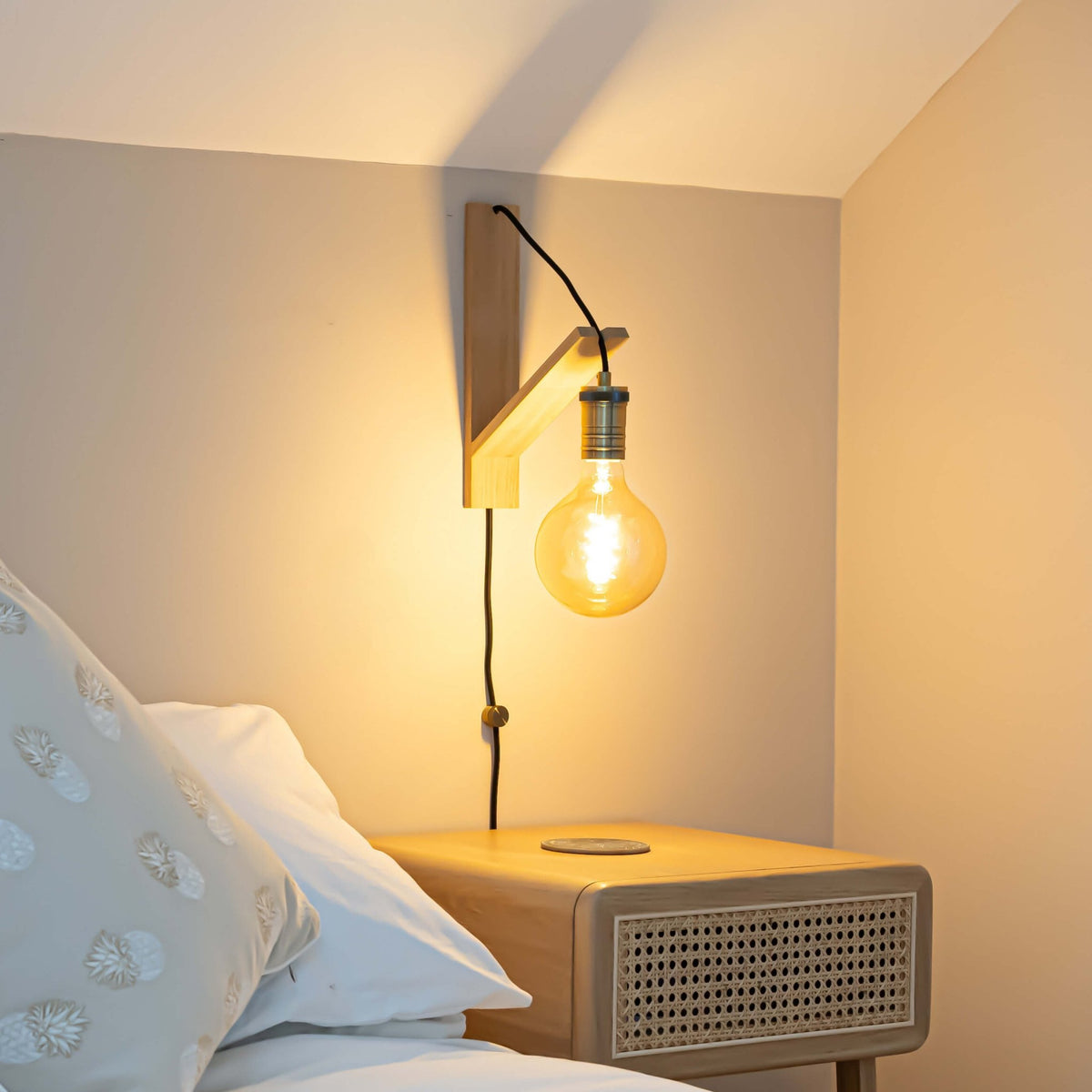 sophia plug in antique brass wall light with straight cable mounted by a bed