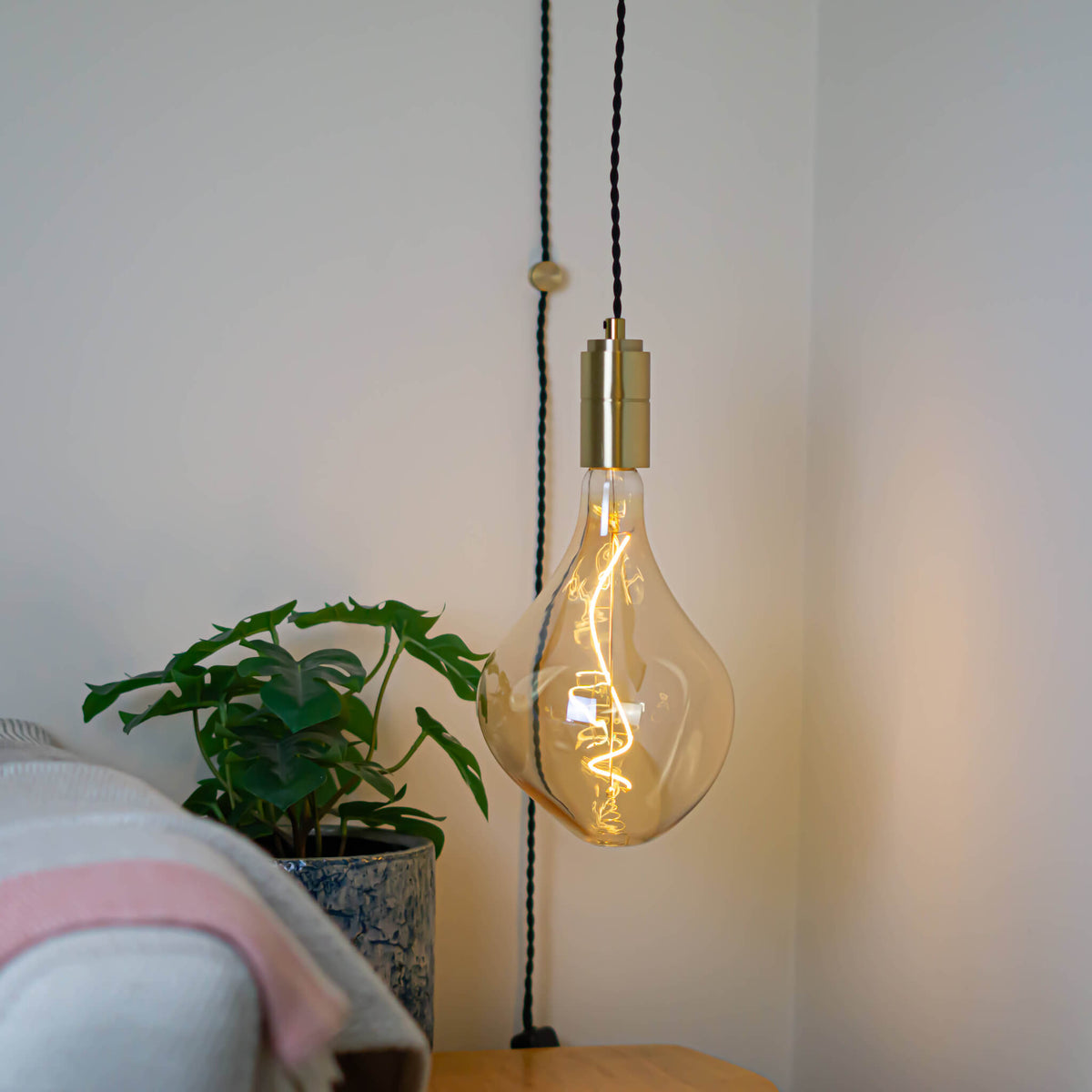 brass plug in pendant light and twisted cable with celeste bulb in living room on