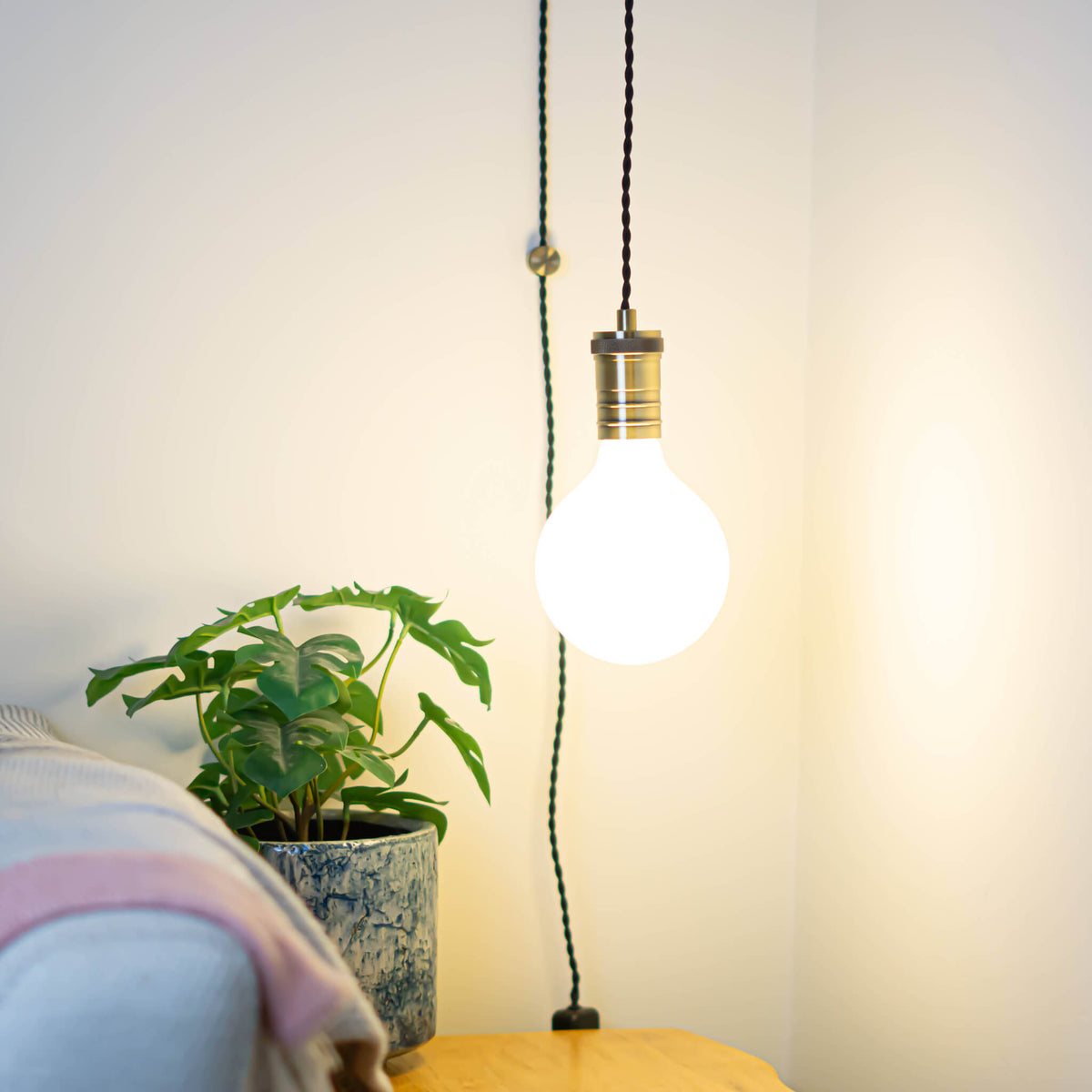 antique bronze plug in pendant light and twisted cable luna bulb in living room on
