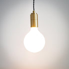 brass pendant light with twisted cable and luna bulb on