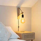 sophia plug in matte black wall light mounted by a bed